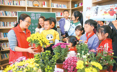 10月19日，在江蘇省如皋市城南街道肖陸村農(nóng)家書屋，小朋友賞菊花、學(xué)習(xí)霜降節(jié)氣習(xí)俗。徐 慧攝（人民視覺）