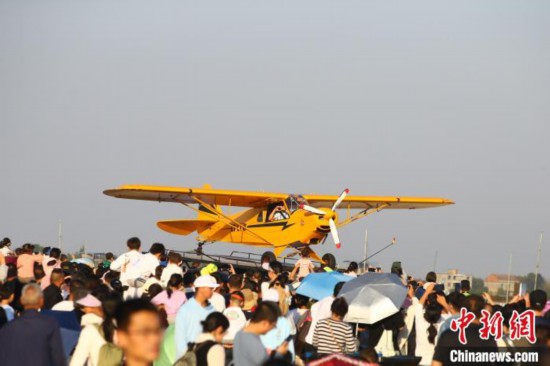 11月3日，江西南昌，立陶宛阿德瑞斯特技飛行表演隊(duì)機(jī)務(wù)人員向現(xiàn)場(chǎng)觀眾“比心”打招呼。中新社記者 劉占昆 攝