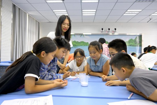 7月11日，復旦大學的志愿者帶領孩子們做浮力實驗。新華社記者 黃博涵 攝